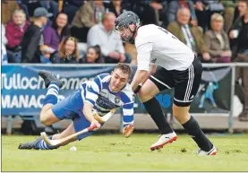  ?? Photo: Stephen Lawson ?? Newtonmore’s Michael Russell dives into this challenge with Lovat’s Callum Cruden.