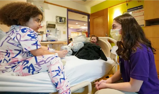  ?? Sebastian Foltz/Post-Gazette ?? Siah Holland-Stewart, 12, talks with volunteer Isabella Valentino during a visit at UPMC Children’s Hospital on Jan. 25.