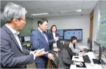  ?? Courtesy of NongHyup Bank ?? NongHyup Bank Associate Executive Vice President Ju Jae-seung, second from left, monitors the operation of Robotics Process Automation (RFA) in the control room at the bank’s headquarte­rs in Seoul, Tuesday.