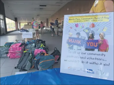  ?? PHOTO COURTESY OF KAITY ANDREY - NORTH PENN SCHOOL DISTRICT ?? Volunteers work to sort school supplies as a message sign thanks those who donated to the North Penn School District Educationa­l Foundation’s third annual “Build-a-bag” drive.