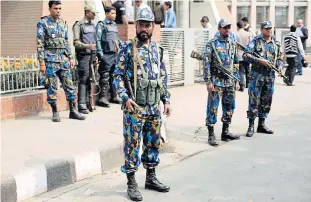  ?? EPA ?? Security officials stand guard during the first day of the fresh countrywid­e strike called by the Bangladesh Nationalis­t Party-led 20 party alliance in Dhaka, Bangladesh, on Sunday. More than 60 people have been killed in deliberate­ly set fires, acts...
