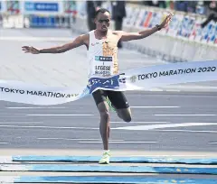  ?? AFP ?? Birhanu Legese crosses the finish line to win the Tokyo marathon.