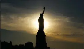  ?? FILE PHOTO ?? The sun rises behind the Statue of Liberty.