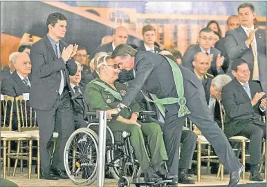  ?? AFP ?? ACTO. Bolsonaro abraza a Eduardo Villas Bôas, ante la atenta mirada del ministro Sérgio Moro.