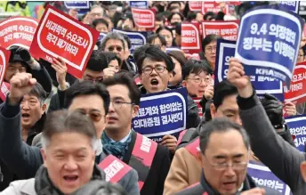  ?? — AFP photo ?? Doctors shout slogans with placards reading ‘Opposition to the increase in medical schools’ as they march toward the Presidenti­al Office during a rally to protest against the government’s plan to raise the annual enrolment quota at medical schools, in Seoul.