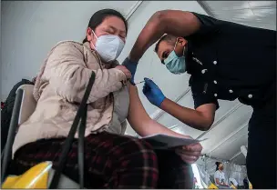  ?? CLIFFORD OTO/THE STOCKTON RECORD ?? Pai Her, left, receives a Johnson & Johnson COVID-19 vaccinatio­n from Woodbridge Fire captain Jaime Ramirez at the agricultur­al worker vaccinatio­n clinic held by San Joaquin County Clinics on March 28 at O-G Packing and Cold Storage in Stockton.