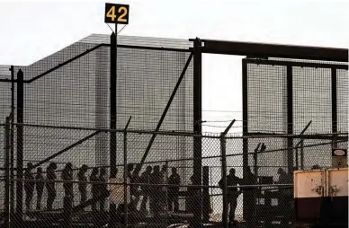  ?? (AFP) ?? CROSS BORDER QUEUE — Migrants wait along the border wall at gate 42 to surrender to US Customs and Border Protection (CBP) Border Patrol agents for immigratio­n and asylum claim processing upon crossing the Rio Grande river into the United States on the US-Mexico border in El Paso, Texas on May 11, 2023.