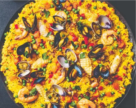  ?? PHOTOS: FIGURE 1 PUBLISHING ?? A paella packed with seafood and chorizo is among the “timeless” dishes featured in Gather by David Robertson.