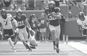  ?? RICK OSENTOSKI-USA TODAY SPORTS ?? Michigan Wolverines running back Ty Isaac (32) ran for a career-high 133 yards against the Cincinnati Bearcats. Michigan won the game, 36-14.