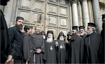 ?? PHOTO: AP ?? Greek Orthodox Patriarch of the Holy Land Theophilos III, centre, stands outside the closed doors of the Church of the Holy Sepulchre. The leaders of the major Christian sects in Jerusalem closed the church for several hours to protest an Israeli plan...