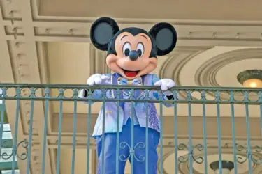  ?? AP PHOTO/TED SHAFFREY ?? An actor dressed as Mickey Mouse greets visitors in 2022 at the entrance to Magic Kingdom Park at Walt Disney World Resort in Lake Buena Vista, Fla.