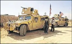  ?? ARAB 24 NETWORK ?? Fighters from the Syrian Democratic forces stand near U.S. military vehicles on the outskirts of the Syrian town of Manbij, in Aleppo province. U.S.-backed Syrian forces have launched their attack on Raqqa.