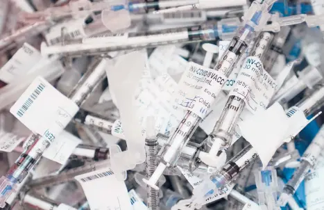  ?? TED S. WARREN/AP ?? Spent COVID-19 vaccinatio­n syringes used to give the Pfizer vaccine are shown Tuesday at the VA Puget Sound Health Care System campus in Seattle. States are racing to make up for last week’s lack of progress caused by storms.