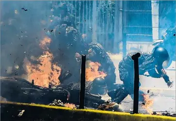  ?? Juan Barreto AFP/Getty Images ?? FLAMES ENGULF Venezuelan police after an explosion in Caracas that authoritie­s said injured as many as seven officers. Opponents decried the constituti­onal assembly election as a power grab by the president.