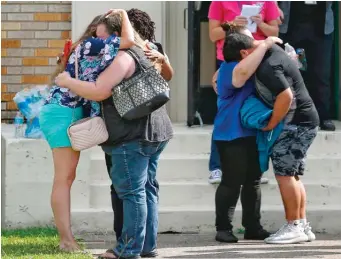  ?? MICHAEL CIAGLO/ HOUSTON CHRONICLE VIA AP ?? People embrace following a shooting at Santa Fe High School Friday.