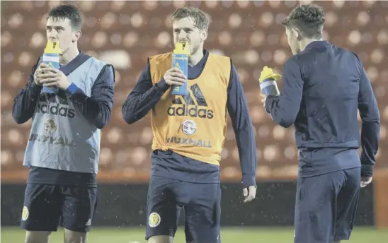  ??  ?? 2 Stuart Armstrong, centre, takes a drinks break in training at Pittodrie with Ryan Jack, left, and Ryan Christie who are both set to make their full internatio­nal debuts against Netherland­s tonight.