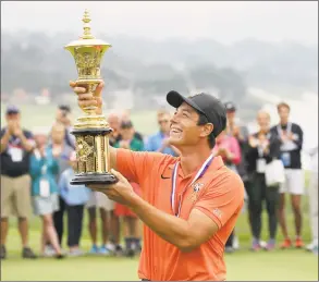  ?? Eric Risberg / AP ?? Norway’s Viktor Hovland holds up the Havemeyer Trophy on the 13th green of the Pebble Beach Golf Links after winning the USGA Amateur Golf Championsh­ip on Aug. 19, 2018, in Pebble Beach, Calif.