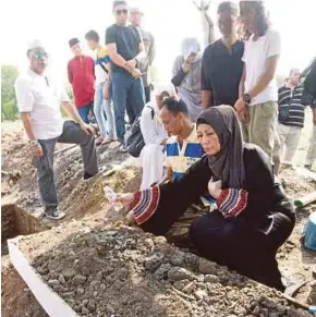  ?? (Foto Mustaffa Kamal/bh) ?? Isteri, Ramlah Ahmad menyiram air mawar di pusara Yazit di Tanah Perkuburan Islam Raudatul Sakinah Taman Selasih.