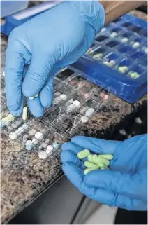  ?? CHRIS WATTIE • REUTERS ?? A pharmacist counts prescripti­on drugs at the at the Centretown Pharmacy in Ottawa in 2019.