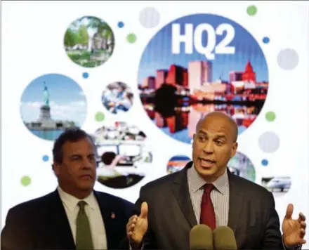  ?? SETH WENIG — THE ASSOCIATED PRESS FILE ?? New Jersey Sen. Cory Booker, right, speaks while New Jersey Gov. Chris Christie stands behind him during an announceme­nt in Newark, N.J. Officials in Newark, which was one of the 18 finalists that Amazon rejected in November when it announced it would split its HQ2 between New York and northern Virginia, sent a giant heart that said “NJ &amp; Newark Still Love U, Amazon!” The love note came despite Amazon saying it’s not seeking a new site.