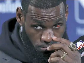  ?? Associated Press ?? LeBron James listens to a question at a postgame news conference after Game 2 of the NBA Finals Sunday night in Oakland, Calif.