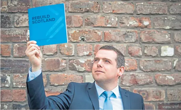  ??  ?? READ ALL ABOUT IT: Douglas Ross holds aloft his party’s election plans to rebuild Scotland after the pandemic at the manifesto launch in Glasgow.
