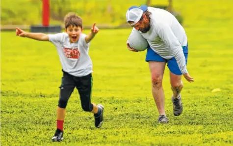  ?? STAFF PHOTO BY C.B. SCHMELTER ?? Seven-year-old Charlie Johnson, left, celebrates after Ryan Coulter makes a catch during a Try Kidz kickball game at Jefferson Heights Park.