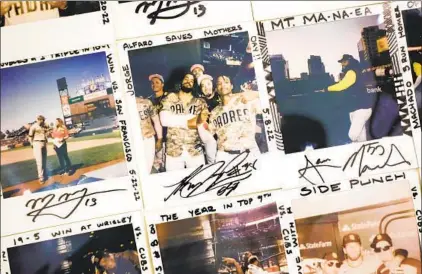  ?? K.C. ALFRED U-T PHOTOS ?? Polaroids taken by Padres players, most signed by the main subject, hang in the hallway leading to the dugout at Petco Park.