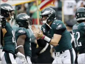  ?? MATT ROURKE — THE ASSOCIATED PRESS ?? The Philadelph­ia Eagles’ Carson Wentz cheers on his team before a game against the Arizona Cardinals in Philadelph­ia. The Eagles face the Carolina Panthers in a Thursday night showdown.