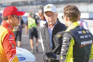  ?? AJ MAST/ASSOCIATED PRESS ?? Roger Penske, center, speaks with drivers Joey Logano, left, and Ryan Blaney before practice for a 2022 NASCAR race at Indianapol­is Motor Speedway. A new NASCAR season begins with rivals attempting to dethrone Team Penske after two years atop the Cup Series, all while a compelling off-track battle rages on over revenue sharing that threatens to overshadow the competitio­n.