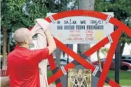  ?? MARIA LORENZINO/STAFF PHOTOGRAPH­ER ?? Preston Smith shines a pentagram, his “monument to Satan” provided by the Freedom from Religion Foundation, in Boca Raton’s Sanborn Square on Tuesday.