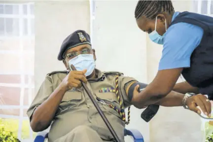  ??  ?? A police officer has his blood pressure taken before receiving a shot of the Astrazenec­a COVID-19 vaccine, manufactur­ed by the Serum Institute of India and provided through the global COVAX initiative, in Machakos, Kenya, Wednesday.