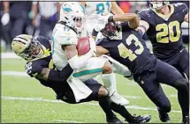  ?? ?? Miami Dolphins wide receiver Jaylen Waddle (17) is tackled by New Orleans Saints’ C.J. Gardner-Johnson (22) and Marcus Williams (43) after catching a pass during the first half of an NFL football game in New Orleans. (AP)