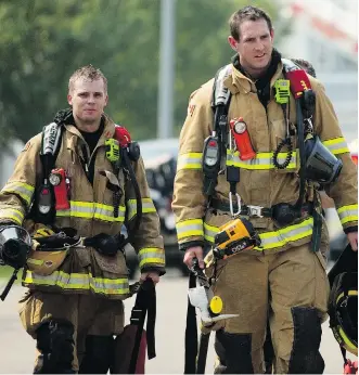  ?? PHOTOS BY LEAH HENNEL ?? Firefighte­rs at the scene of a multiple house fire on Los Alamos Crescent on Friday. About two dozen firefighte­rs battled the flames amid record high temperatur­es.