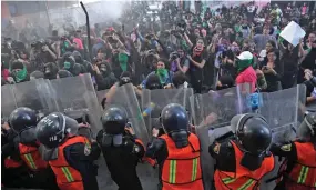  ??  ?? Protesters clash with police as women march in Mexico City on Friday to protest gender violence. Photo: AFP.