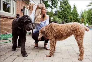  ?? The Washington Post/MICHELLE GUSTAFSON ?? Stefanie Joho, 27, plays with a friend’s dogs, Dylan and Nellie, in Penn Valley, Pa. Joho was part of a small trial in Baltimore showing that immunother­apy could attack certain cancers thought to be unstoppabl­e.