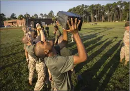  ?? STEPHEN B. MORTON — THE ASSOCIATED PRESS ?? A group of male U.S. Marine Corps recruits train with weighted ammo cans during a physical training exercise at the Marine Corps Recruit Depot in Parris Island, S.C., on June 28.