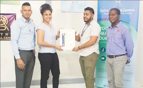  ?? ?? Mahesh and Marina Itwaru receiving their certificat­ion from GNBS staff at a ceremony on Thursday
