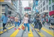  ?? AFP ?? ■ Hong Kongers cross a road in Wanchai district on Thursday.