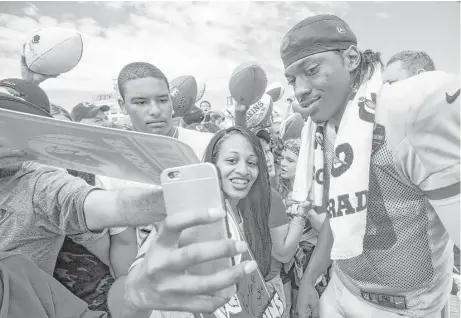  ?? Brett Coomer / Houston Chronicle ?? Washington quarterbac­k Robert Griffin III makes time for adoring fans Saturday at Redskins training camp in Richmond, Va.