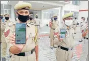  ?? ANI ?? Policemen display the Aarogya Setu app in J&K’s Reasi.