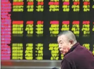  ?? FENG YONGBIN / CHINA DAILY ?? An investor checks out stock movements at a brokerage in Beijing on Friday, the first trading day of the Year of the Rooster.