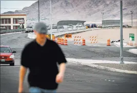  ?? DAVID BECKER/ LAS VEGAS REVIEW-JOURNAL ?? A man walks along North Stephanie Street just south of the bridge over U.S. Highway 95 in Henderson on Monday. Work is scheduled to begin this month on the bridge, with improvemen­ts to add traffic lanes and other safety features.