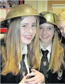  ??  ?? Soldier on S1 pupils Holly Fordyce and Kayleigh McAlpine in tin hats