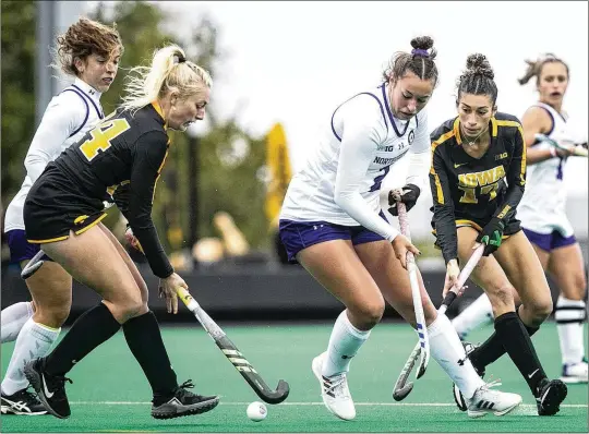  ?? JOSEPH CRESS/IOWA CITY PRESS-CITIZEN VIA AP ?? Northweste­rn’s Lauren Wadas (center) battles for possession with Iowa’s Lokke Stribos (left) and Ciara Smith during a Big Ten field hockey game in Iowa City, Iowa. Field hockey and other nonrevenue sports could be in jeopardy as college athletic department­s grapple with the impact of NIL, potential player salaries, conference realignmen­t, TV deals and the expansion of the football playoff and maybe the men’s basketball tournament.