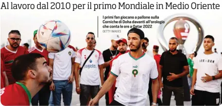  ?? GETTY IMAGES ?? I primi fan giocano a pallone sulla Corniche di Doha davanti all’orologio che conta le ore a Qatar 2022