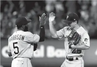  ?? Associated Press ?? Pittsburgh Pirates' Adam Frazier, right, and Josh Harrison celebrate following the team's baseball game against the St. Louis Cardinals on Saturday in St. Louis. The Pirates won, 7-3.