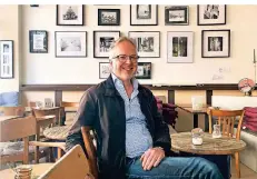  ?? RP-FOTO: MARC INGEL ?? Bernhard Voelz im Café Kausal vor den Bildern von Fabio Bressanell­o. Das Café hat geöffnet, schenkt To-go-Kaffee aus.