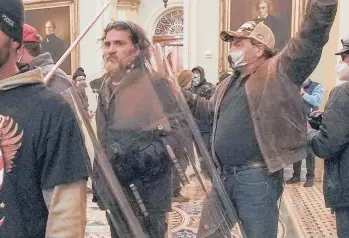  ?? MANUELBALC­E CENETA/AP ?? Proud Boys member Dominic Pezzola carries a police shield Jan. 6 during the Capitol siege. Prosecutor­s allege he had an earpiece in his right ear.“This was not simply a march,”Assistant U.S. Attorney Jason McCullough said.