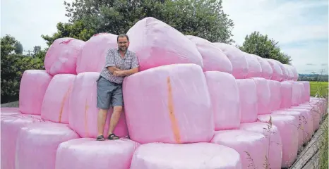  ?? FOTO: MATTHIAS BECKER ?? Landwirt Wolfgang Seiband packt gemähtes Gras in pinkfarben­e Folie: Die Farbe bedeutet, dass vom Verkaufspr­eis Geld in die Brustkrebs­vorsorge fließt. Die Folie ist elastisch, vergleichb­ar mit Frischhalt­efolie im Haushalt.